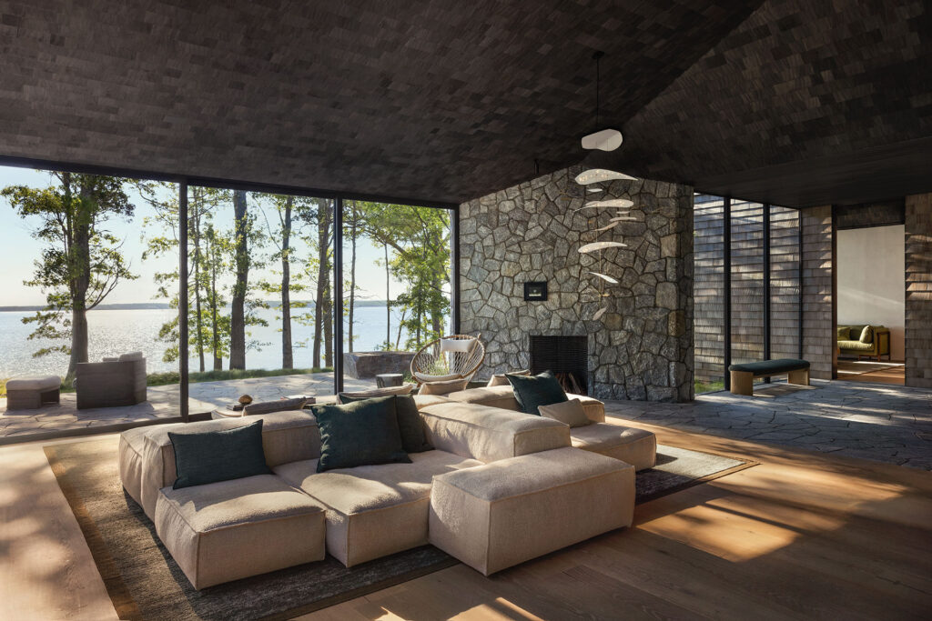 The Bay House — living room with stone fireplace and bay views