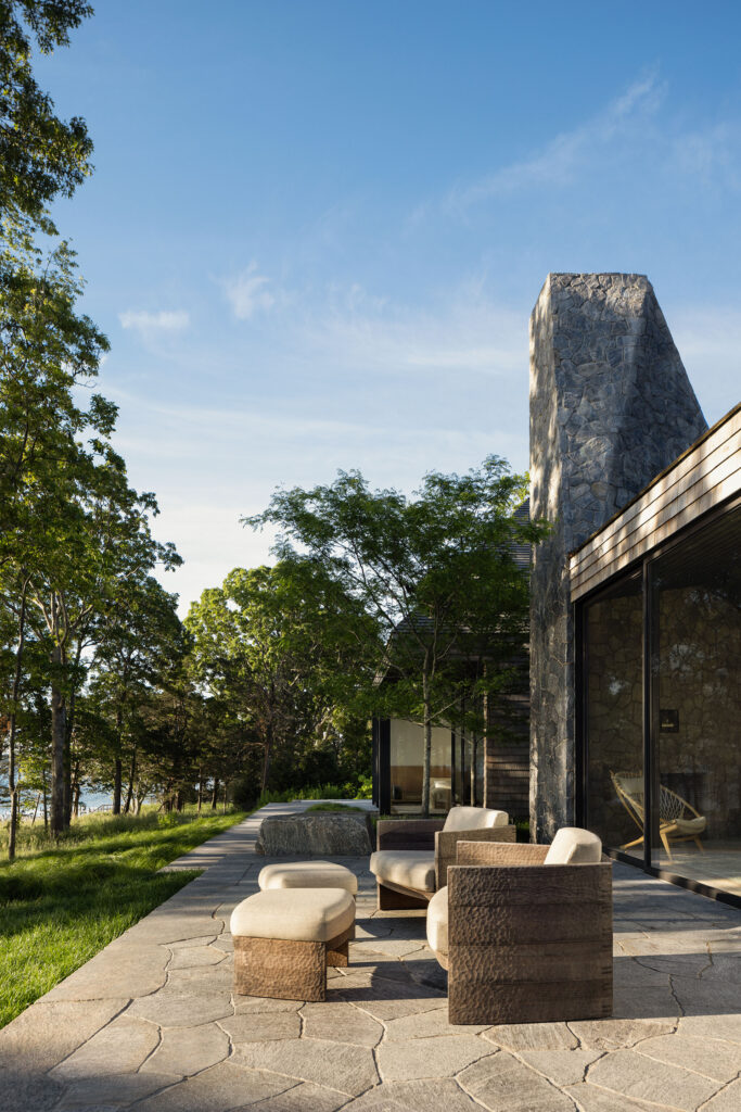The Bay House — stone patio beneath the fieldstone chimney